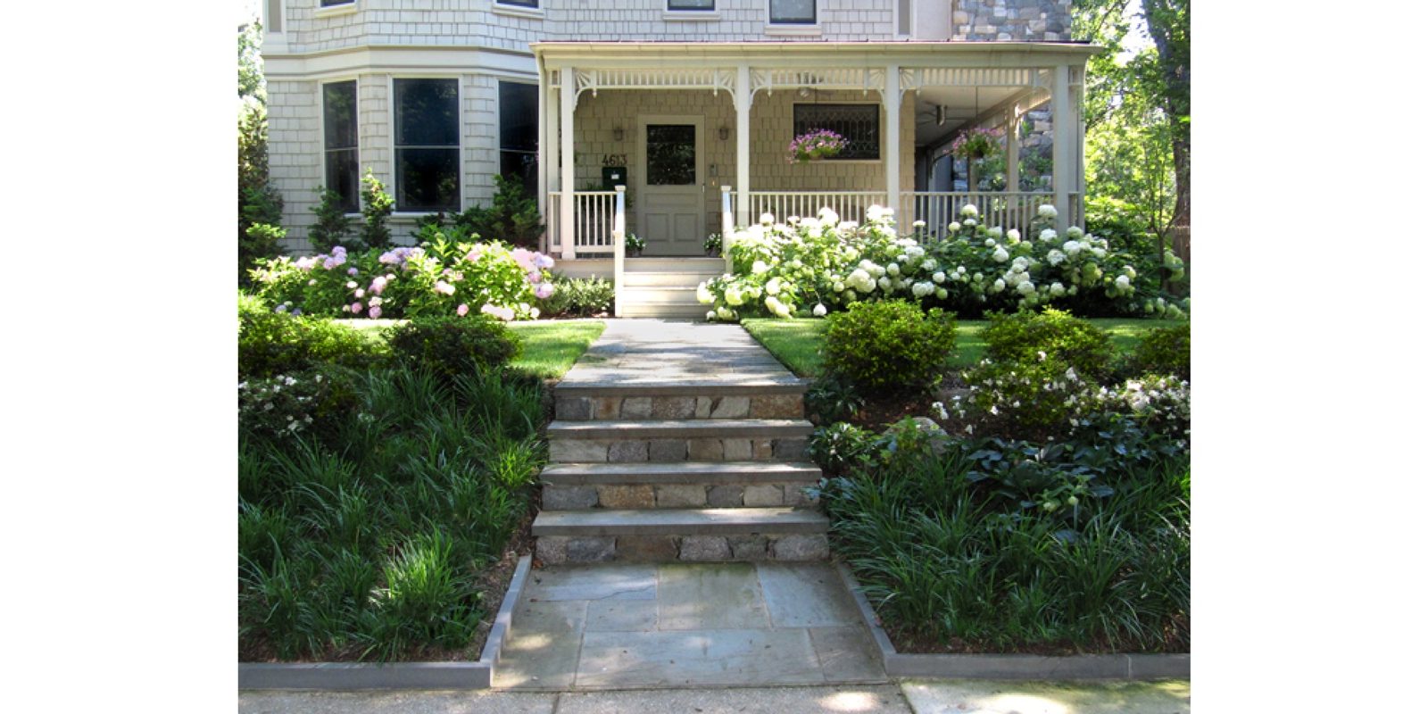 Shrubs and perennials planted along a sunny foundation bed.